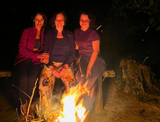 Female guide helping a hiker on a rocky path, showing professionalism